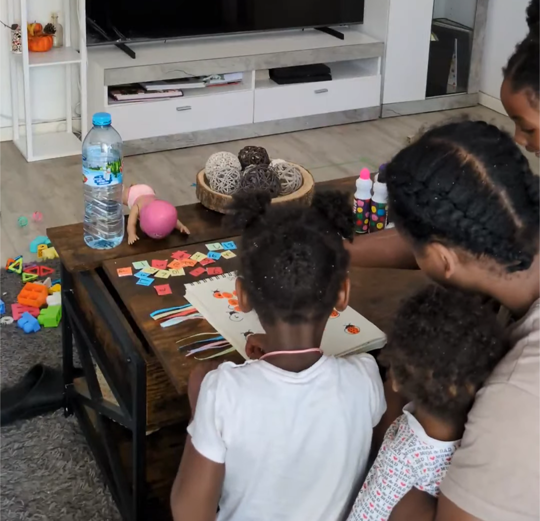 Mother with her kids crafting at the coffee table together