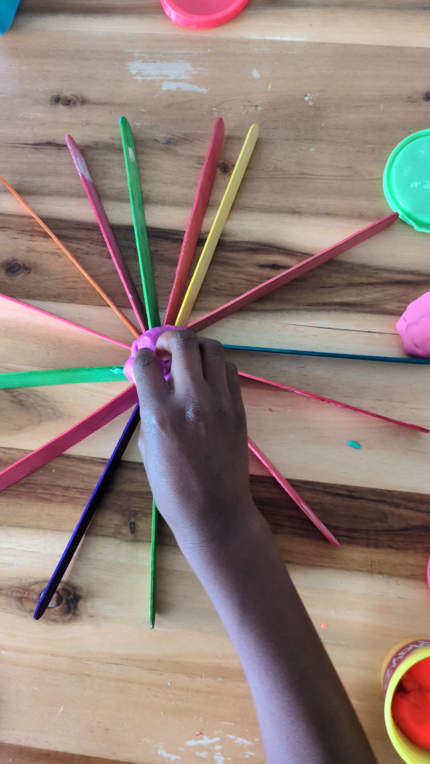 3D geometric shapes and structures built using wooden popsicle craft sticks and small playdough connector balls for a preschool STEAM activity