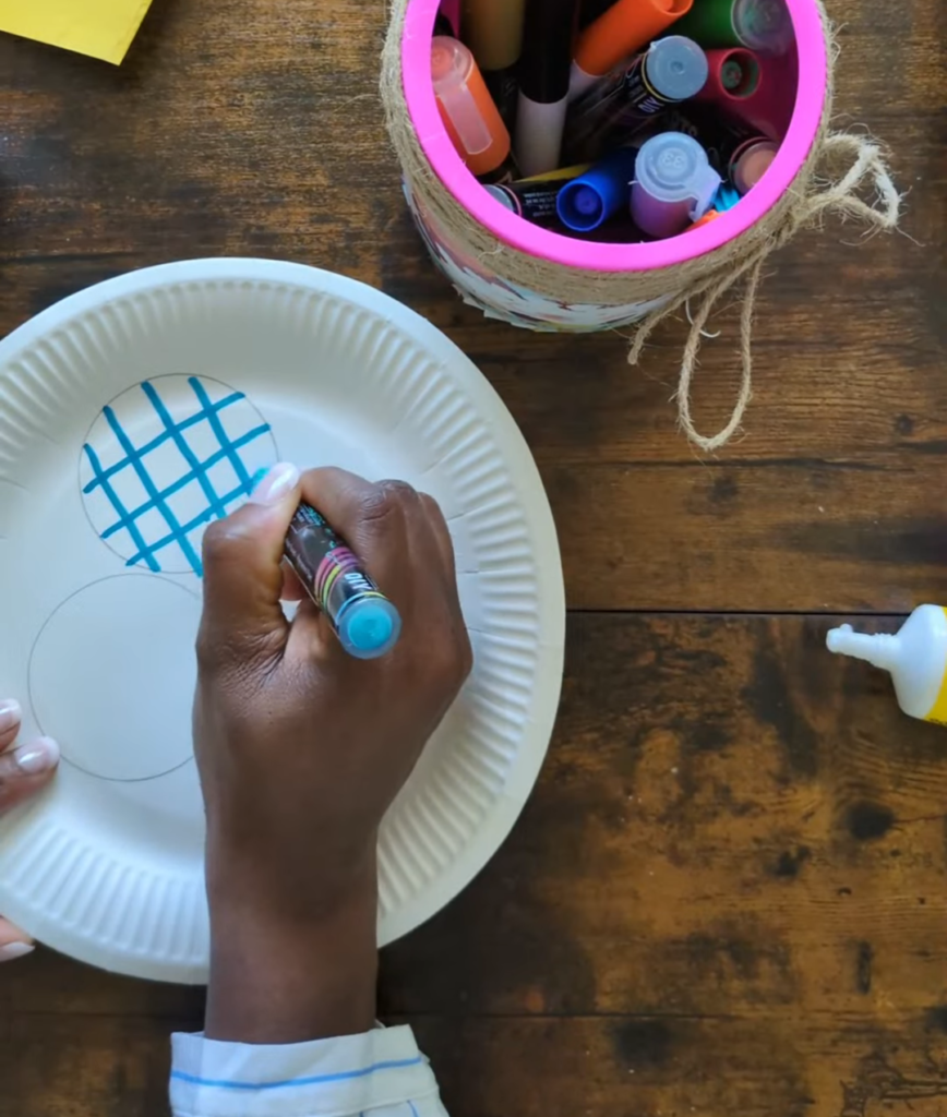 Patterned toilet paper cardboard tubes being stacked into a tower on a paper plate matching game layout for early childhood logical reasoning.