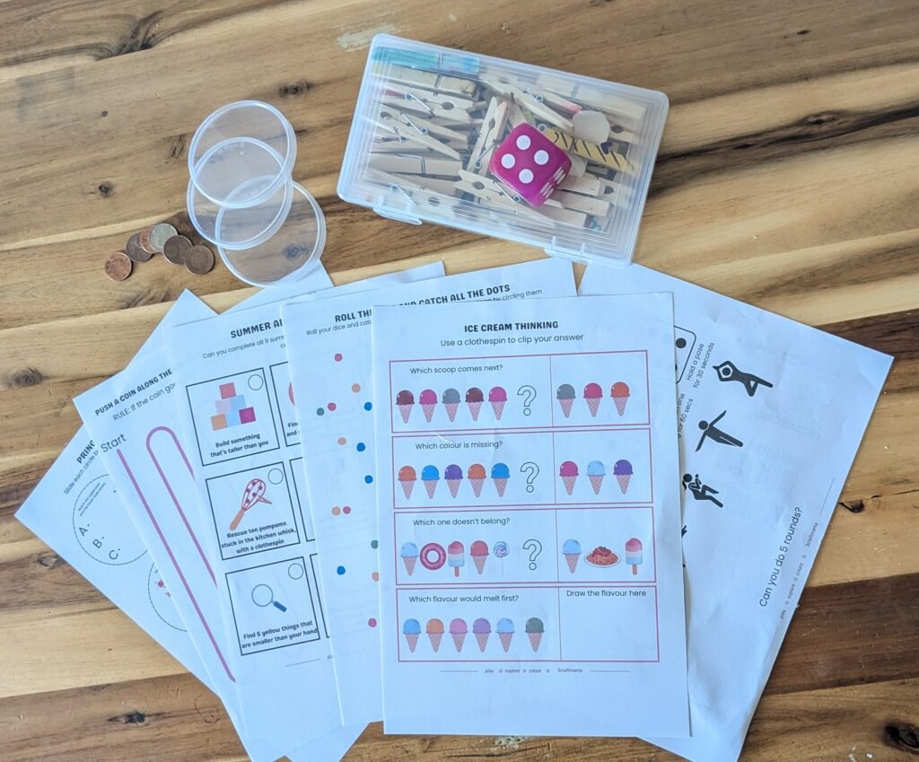 Flatlay of printed children's Play Sparks and colouring layouts on a rustic wooden dining table.